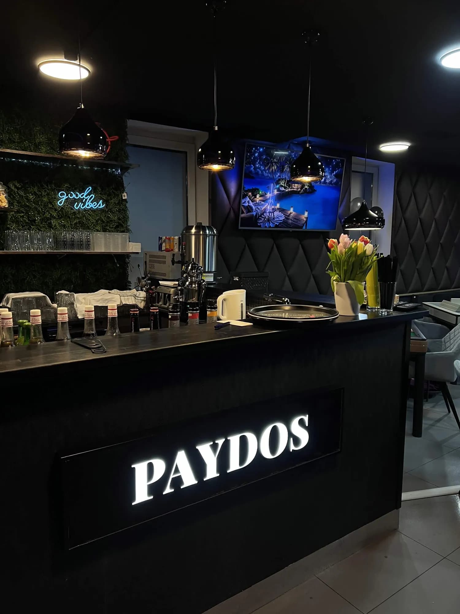 Beleuchtetes Paydos-Schild an der Bar