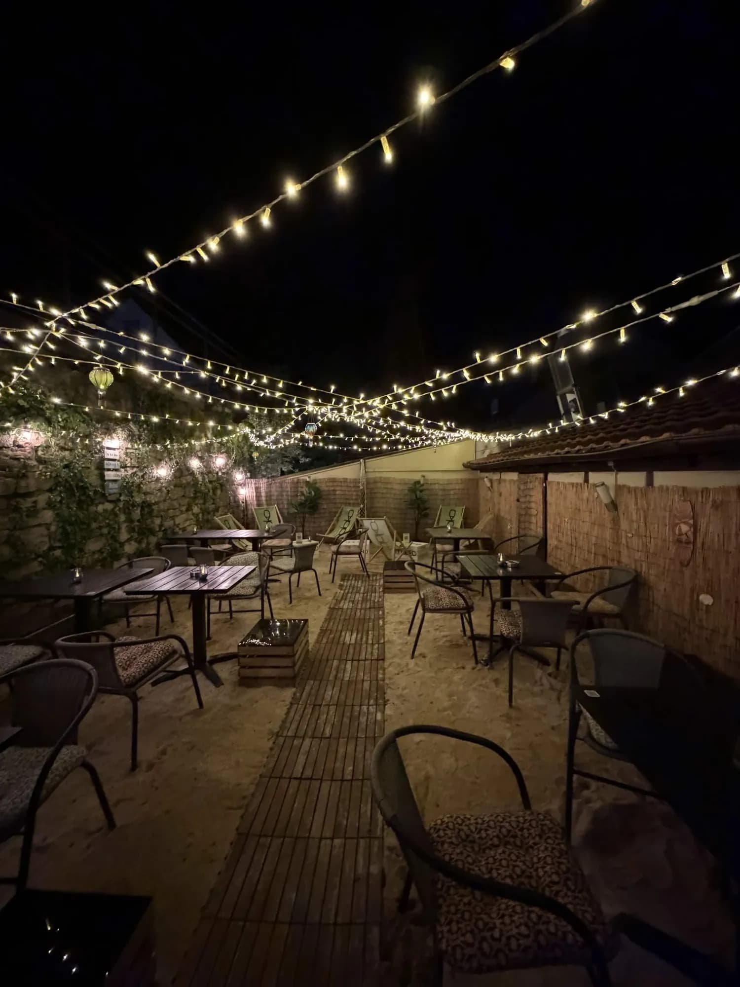 Terrasse der Paydos Lounge mit Lichterketten am Abend