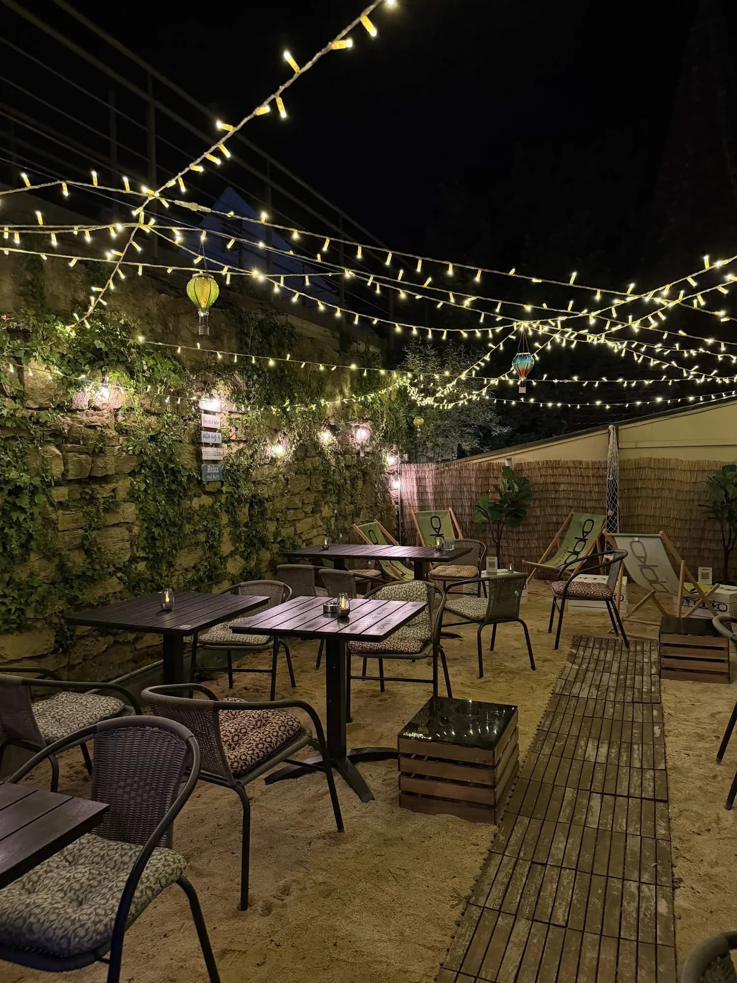 Terrasse mit Lichterketten und Tischen